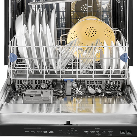 Fully loaded dishwasher with door open, lower rack out and silverware basket visible underneath.