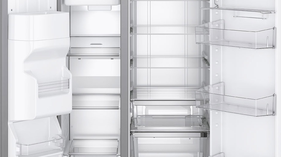 Empty interior of refrigerator and freezer showing many adjustable shelves and bins.